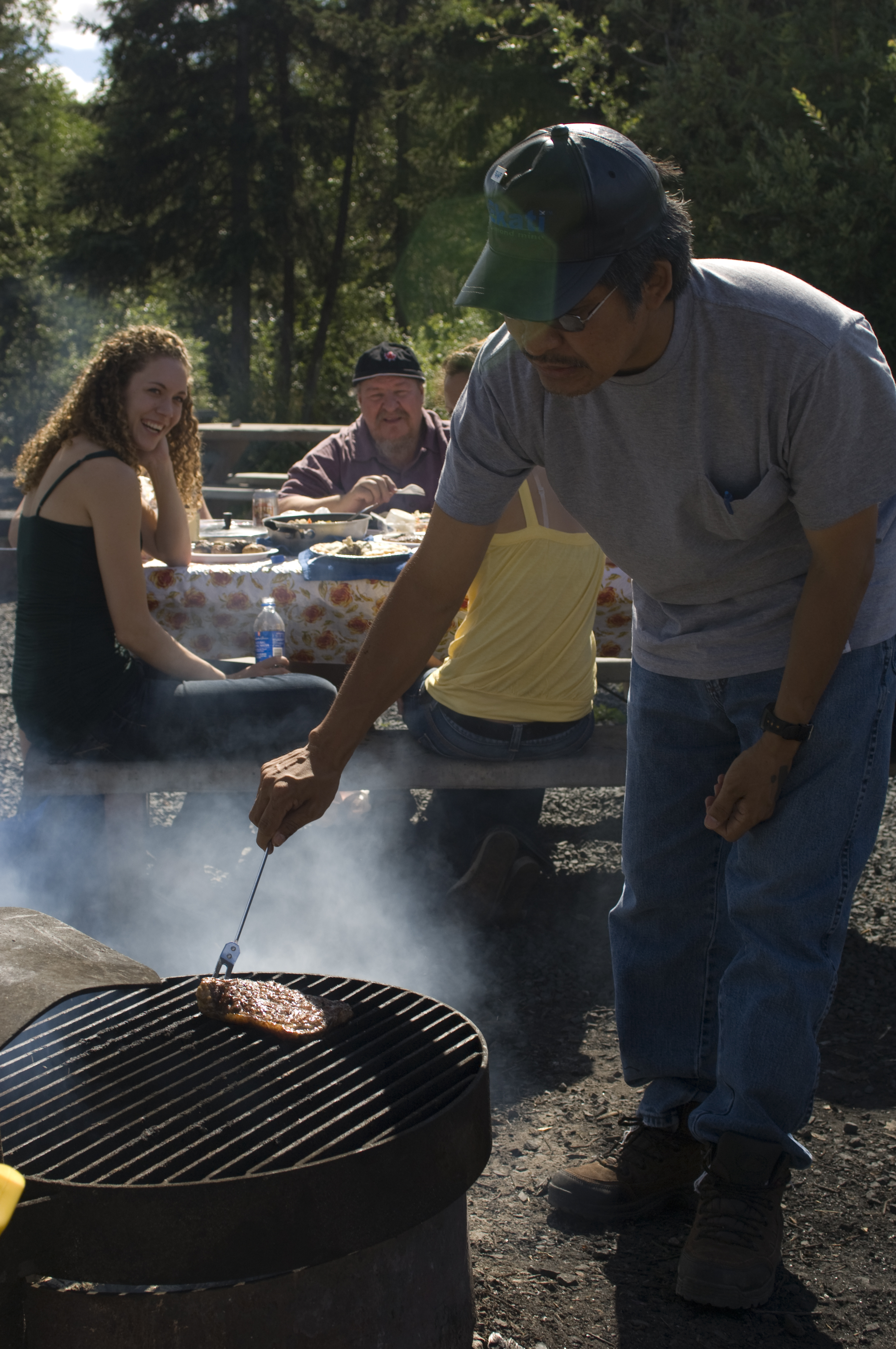 Man cooking over fire at YK River park