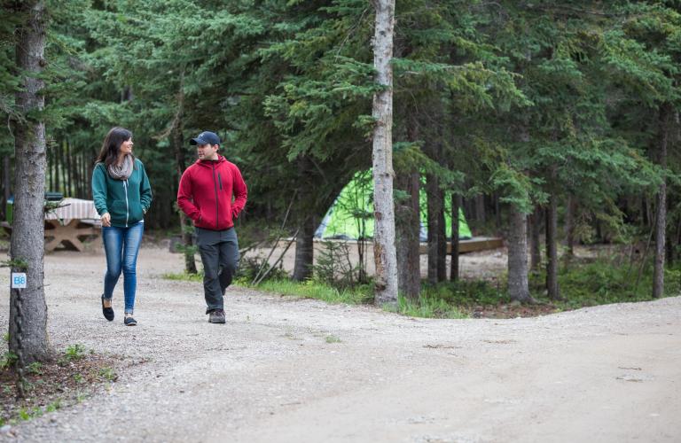Hay River Park campsite, tent and couple walking