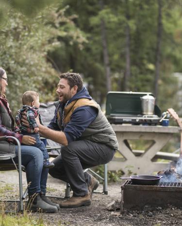 Family at Fred Henne Campground around a fire